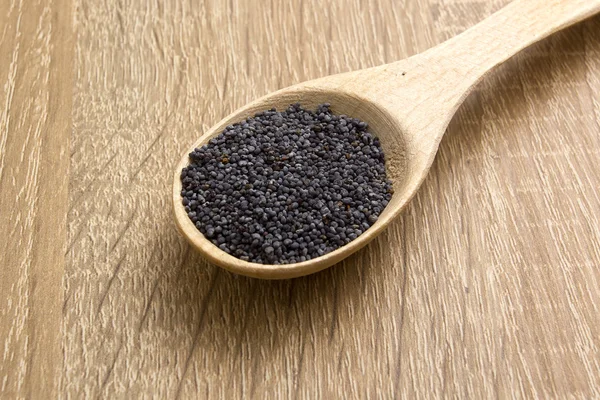 Poppy seeds in a wooden spoon — Stock Photo, Image