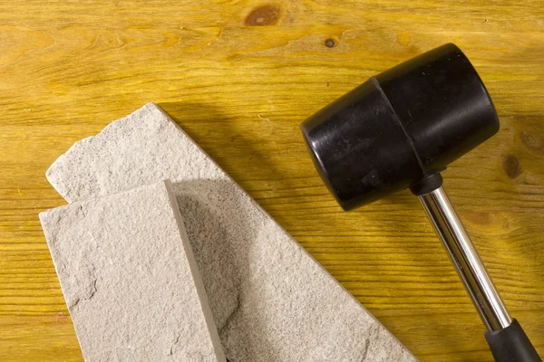 Black rubber mallet and facing stones — Stock Photo, Image