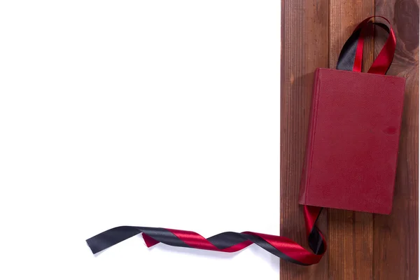 Black red satin ribbon and a book — Stock Photo, Image