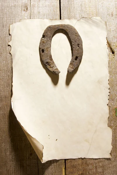 Vecchio ferro di cavallo e un foglio di carta — Foto Stock