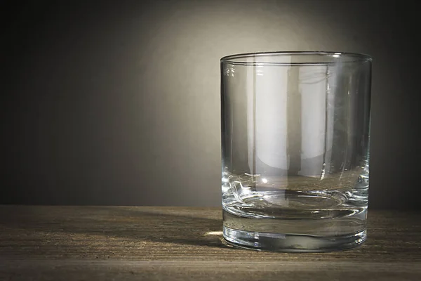 灰色背景木制桌子上的空玻璃杯 — 图库照片