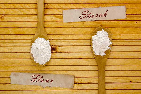 Wooden spoon with flour and starch — Stock Photo, Image