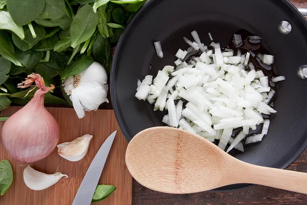 Cebola de redução em uma panela de ato de fritar — Fotografia de Stock