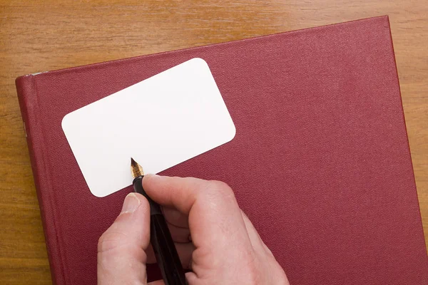 Businessman signs a business card — Stock Photo, Image