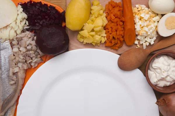 Ингредиенты для салата с сельдью и пустой тарелкой — стоковое фото