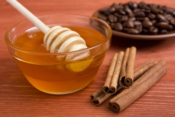 Wooden honey stick with cinnamon sticks — Stock Photo, Image