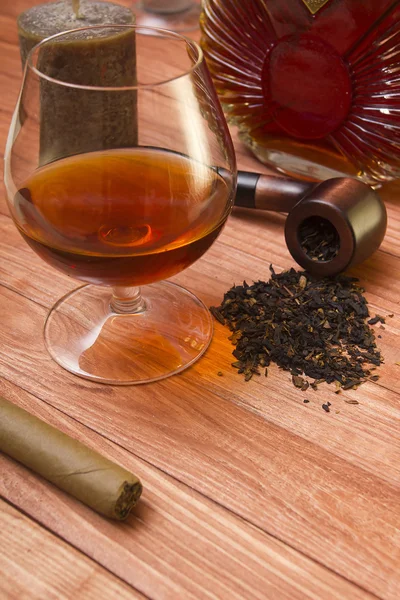 Cognac e pipa di tabacco su un tavolo di legno — Foto Stock