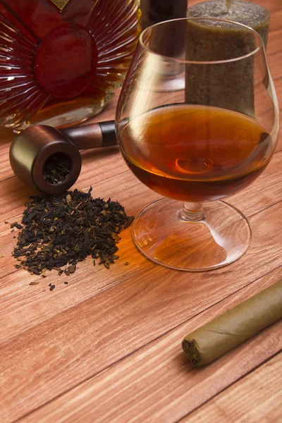 Cognac and tobacco pipe on a wooden table — Stock Photo, Image