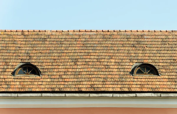 Velho telhado de azulejos com duas janelas sótão — Fotografia de Stock