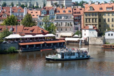 Prag 'ın merkezindeki Vltava Nehri' nde turistlerle dolu eski bir eğlence gemisi.