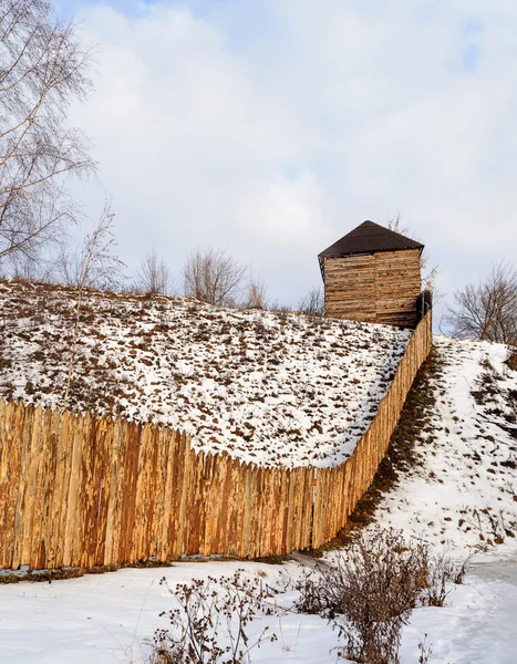 Rough wooden fence on the hill in winter time