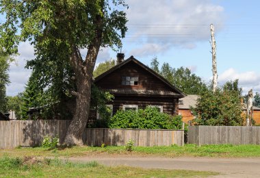 Eski günlük ev önünde büyük bir ağaç ile