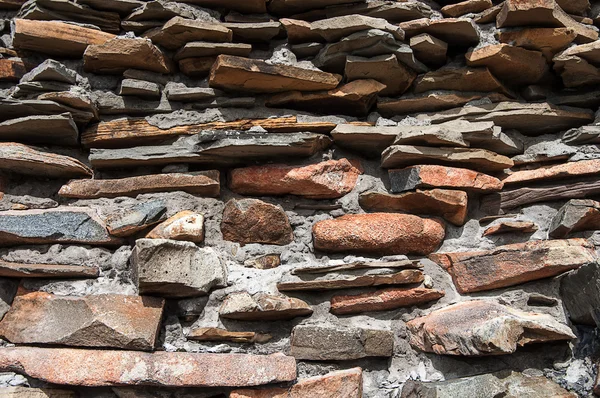 De muur van bruine ruwe stenen — Stockfoto