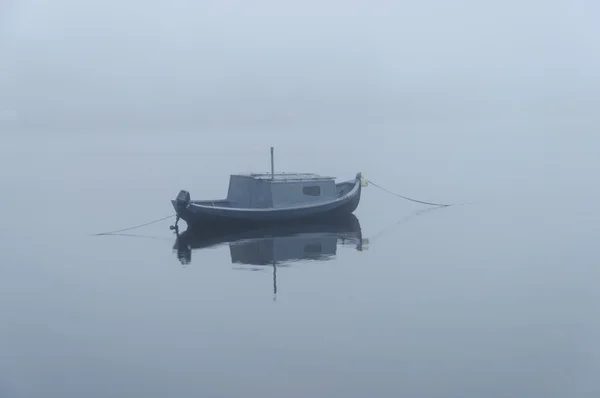 Thick fog on the river, motor boat at anchor Stock Picture