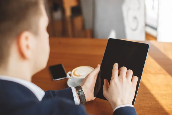 Knappe Man koffie drinken en het gebruik van de Tablet Computer binnenkant Cafe Bar. — Stockfoto