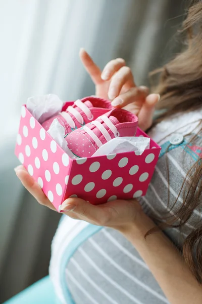 Budoucí mamince s růžové botičky v ruce — Stock fotografie