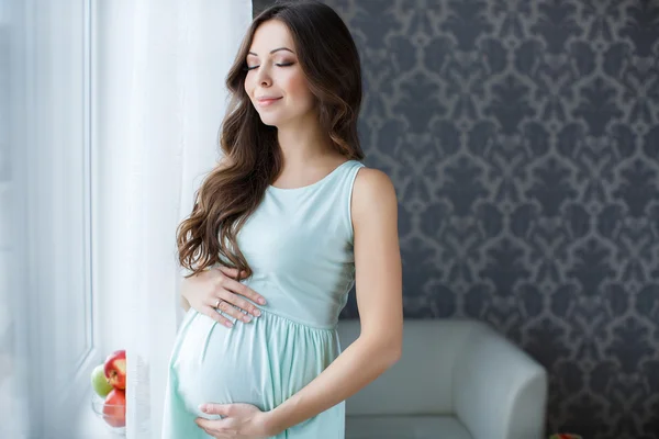 Embarazada mujer tocando manos grande vientre —  Fotos de Stock