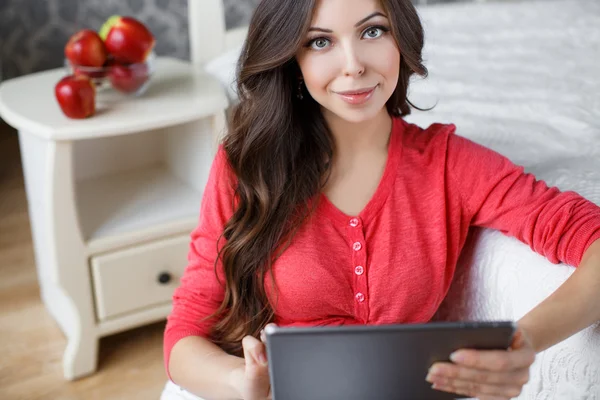 Hermosa mujer embarazada con una tableta en las manos — Foto de Stock