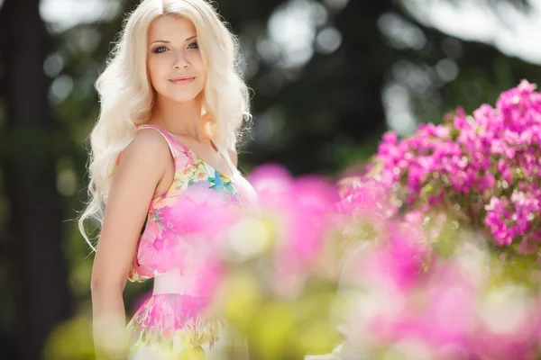 Bella donna sulla terrazza di bianco con fiori rosa — Foto Stock