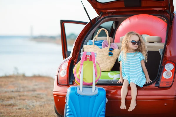 Portret van een meisje zit in de kofferbak van een auto — Stockfoto