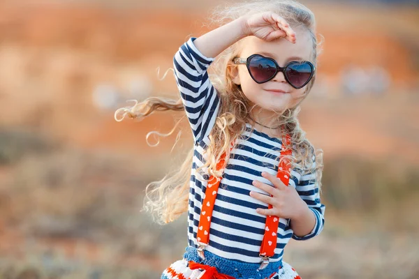 Маленька дівчинка на лузі з сухою травою влітку — стокове фото