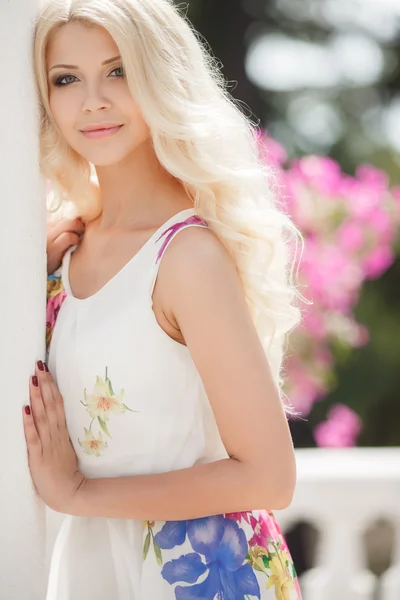 Hermosa mujer en la terraza de blanco con flores de color rosa —  Fotos de Stock