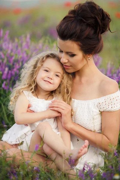 Feliz madre e hija en un campo de lavanda floreciente —  Fotos de Stock