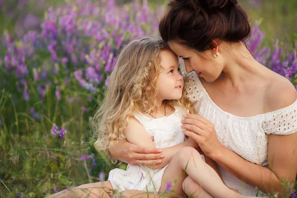 Happy mother and daughter in a field of blooming lavender — Stock Photo, Image