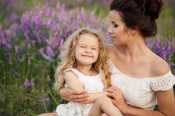 Lycklig mor och dotter i ett fält av blommande lavendel — Stockfoto