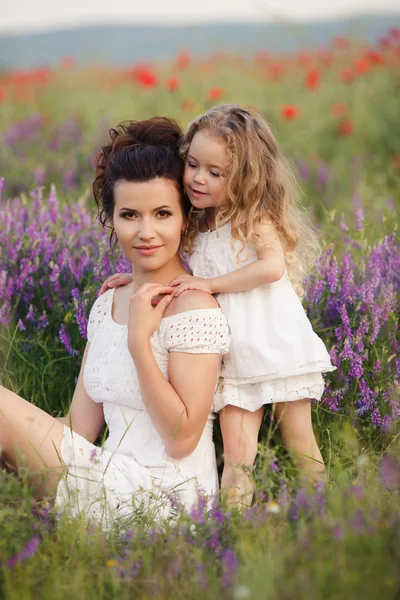 Gelukkige moeder en dochter op een gebied van bloeiende lavendel — Stockfoto