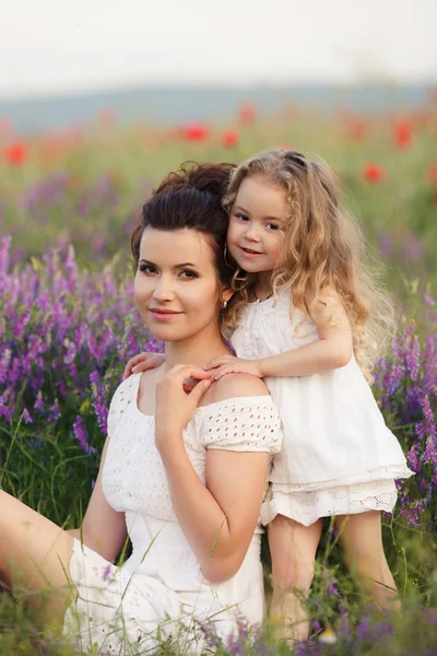 Gelukkige moeder en dochter op een gebied van bloeiende lavendel — Stockfoto