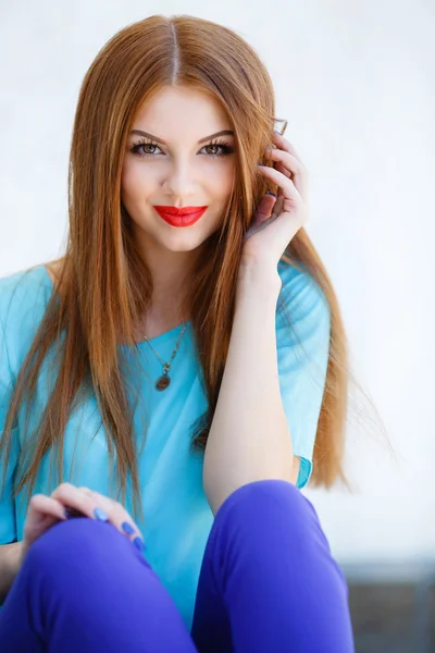 Portrait of beautiful girl with red hair against a light background — Stockfoto