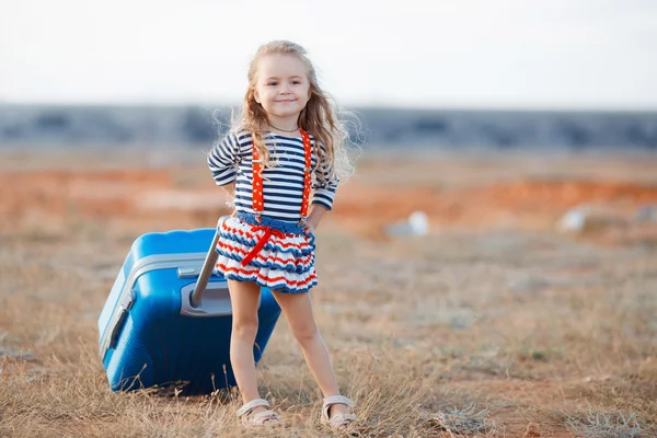 La bambina con una grande valigia blu — Foto Stock