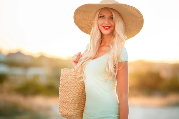 Bright blonde in beautiful hat in the rays of the setting sun — Stock Photo, Image