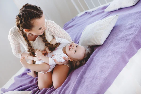 Glückliche Familie, Mutter spielt mit ihrem Baby im Schlafzimmer. — Stockfoto
