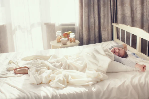 Portrait of a cute little girl, waking up and lying in bed in the morning — Stock Photo, Image