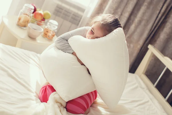 Morning portrait of a little girl waking up,embracing the pillow — Stock Photo, Image