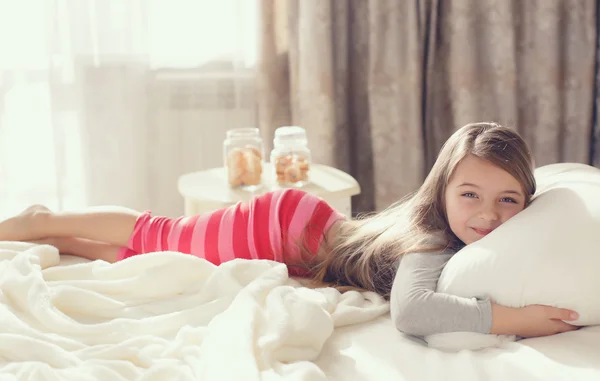 Retrato matutino de una niña despertando, abrazando la almohada — Foto de Stock