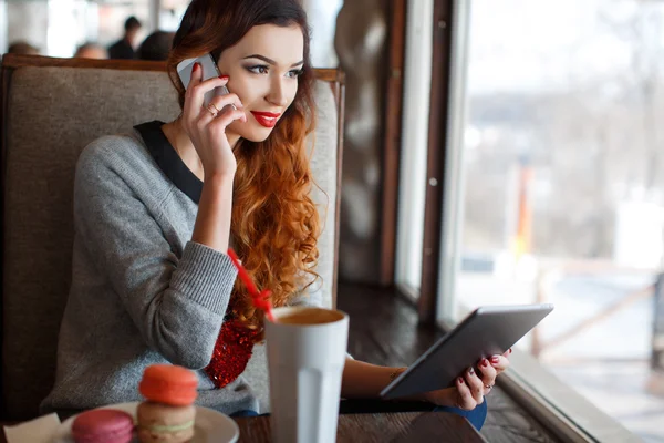 Mädchen in einem Café, das mit einem Handy spricht — Stockfoto