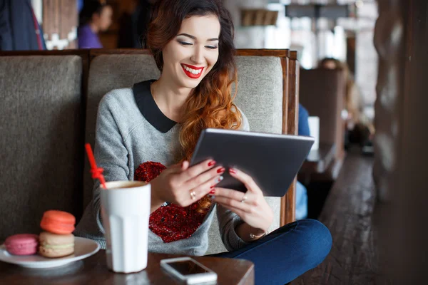 Приваблива молода жінка з планшетного комп'ютера в кафе — стокове фото