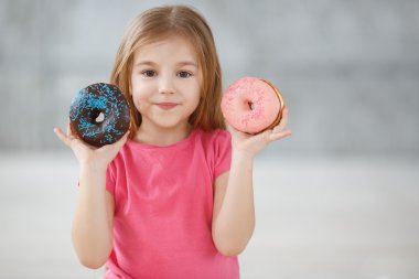 Adorable little girl with a chocolate donut