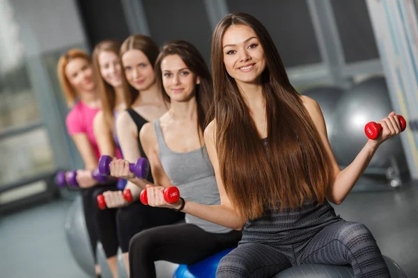 Sportovní dívky v tělocvičně cvičení s činkami — Stock fotografie
