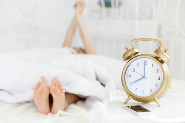 Sleeping girl with alarm clock on a white background — Stock Photo, Image