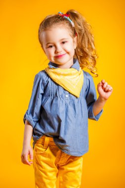 Parlak sarı arka planda komik küçük kız.
