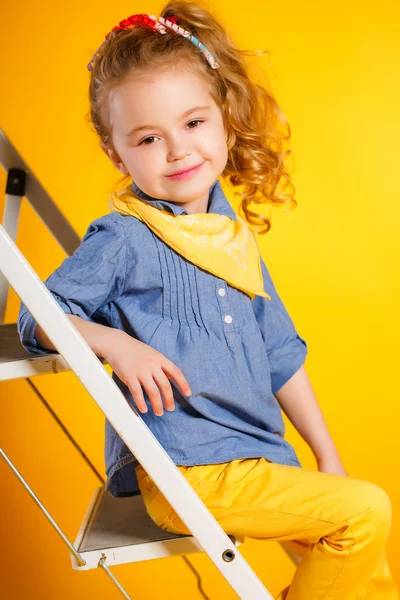 Funny little girl on a bright yellow background. — Stock Photo, Image