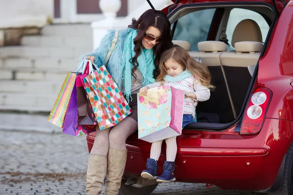 Женщина с ребенком после покупки загружает машину — стоковое фото