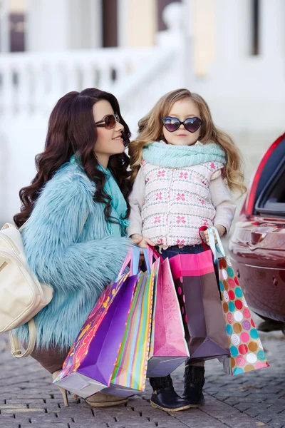 Uma mulher com uma criança depois de fazer compras carregar o carro — Fotografia de Stock
