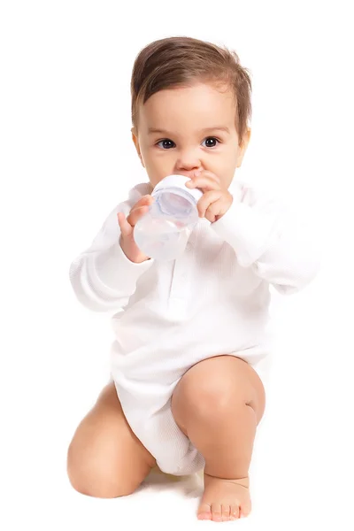 Sweet baby holding bottle and drinking water — Stock Photo, Image