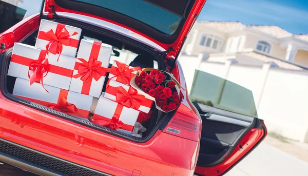 Подарочные коробки в багажнике красной машины — стоковое фото