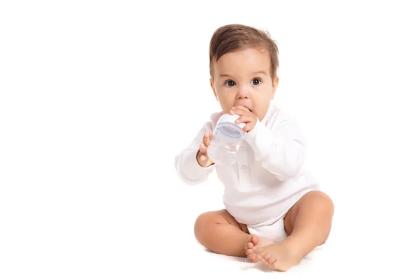 Sweet baby holding bottle and drinking water — Stock Photo, Image